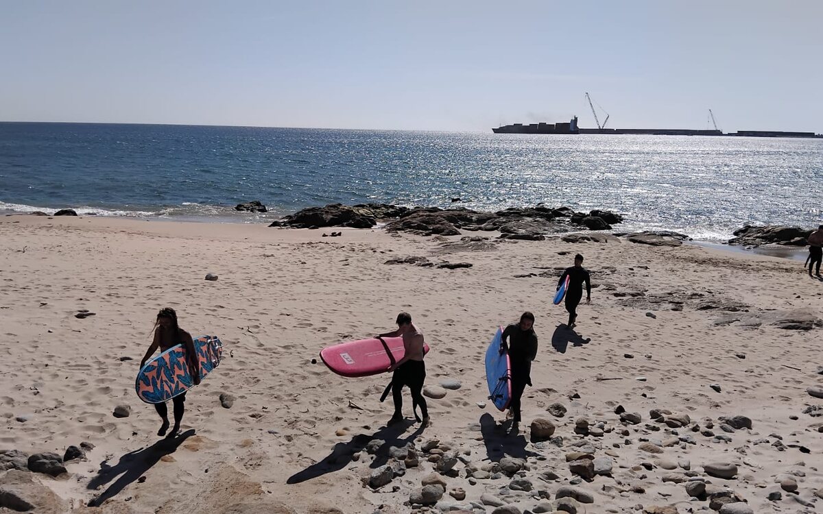 Pessoas a caminho do mar com as pranchas