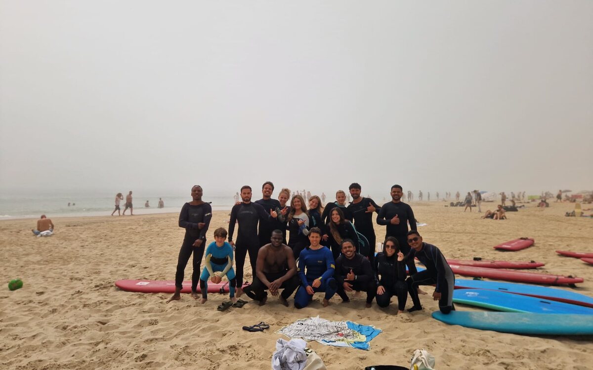 Grupo com pranchas na praia num dia de nevoeiro